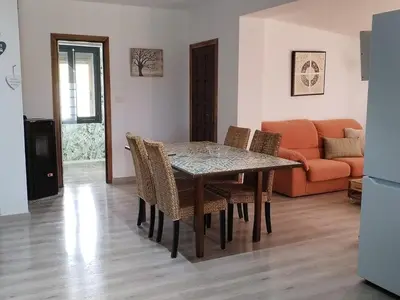 a dining room with a table and chairs and a couch at Casa Quinzan Ribeira Sacra in Taboada