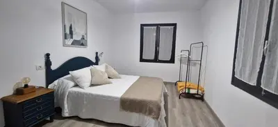 a bedroom with a bed with a blue headboard and a dresser at Casa Quinzan Ribeira Sacra in Taboada