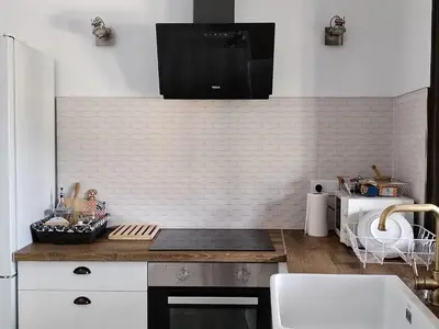 a kitchen with white walls and a counter top at Casa Quinzan Ribeira Sacra in Taboada