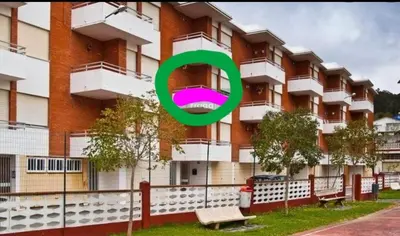 a green circle in front of a building at Apartamento Playa de Ber in Puentedeume