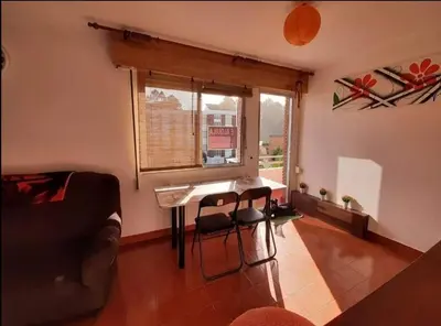 a living room with a table and a window at Apartamento Playa de Ber in Puentedeume