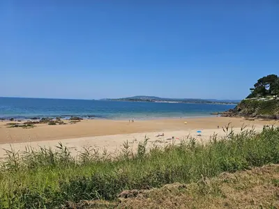 a beach with people on the sand and the water at Apartamento Playa de Ber in Puentedeume