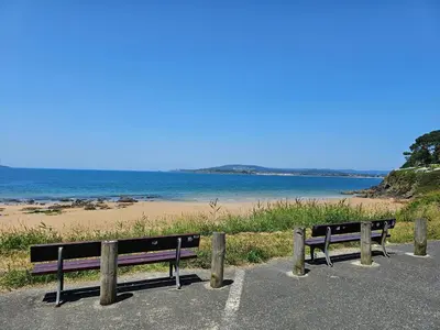 two benches sitting on the side of a beach at Apartamento Playa de Ber in Puentedeume