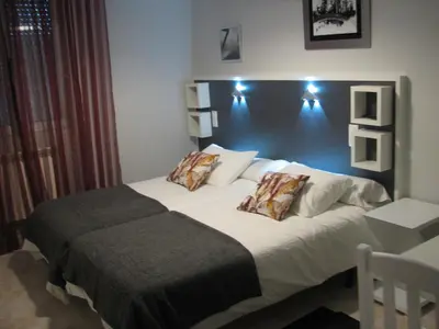 a bedroom with a large bed with two pillows at Hostal Meson do Loyo in Portomarin