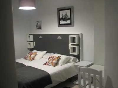 a bedroom with a bed and a table and chairs at Hostal Meson do Loyo in Portomarin