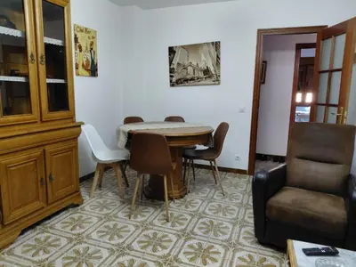 a dining room with a table and a chair at As pitas 2 in Tapia de Casariego
