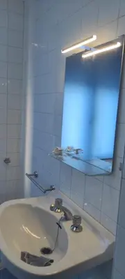 a white bathroom with a sink and a mirror at As pitas 2 in Tapia de Casariego