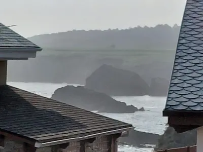 a view of the ocean from the roofs of houses at As pitas 2 in Tapia de Casariego