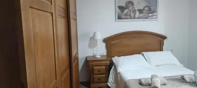 a bedroom with a bed with a wooden headboard and a cabinet at As pitas 2 in Tapia de Casariego
