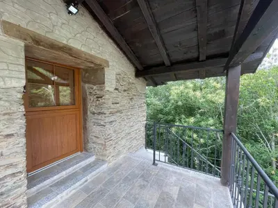 a porch of a stone house with a wooden door at Apartamentos Rurales Casa Carloto