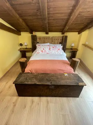 a large bed in a room with wooden ceilings at Apartamentos Rurales Casa Carloto