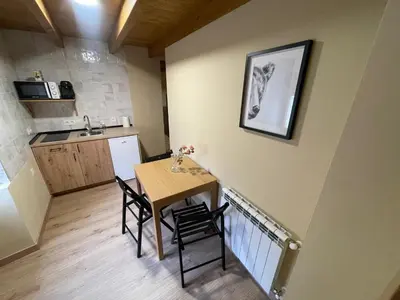 a small kitchen and dining room with a table and chairs at Apartamentos Rurales Casa Carloto