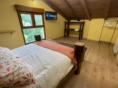 a bedroom with a large bed and a window at Apartamentos Rurales Casa Carloto