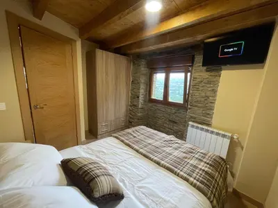 a bedroom with a bed in a room with a window at Apartamentos Rurales Casa Carloto