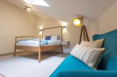 a bedroom with a bed and a blue couch at Luz Marina in Ribadeo