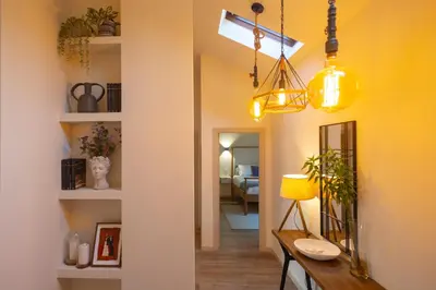 a hallway with yellow walls and a table and lights at Luz Marina in Ribadeo