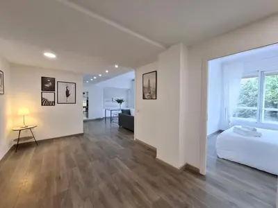 a white room with a bed and a living room at Disfruta de las vistas al Parque de San Lazaro in Ourense