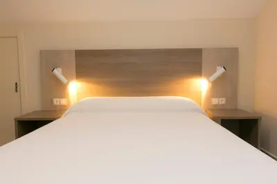 a bedroom with a white bed with two lights at Casa Melva in Barreiros
