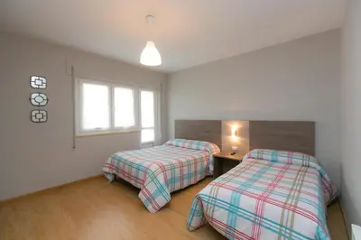 a bedroom with two beds and a window at Casa Melva in Barreiros
