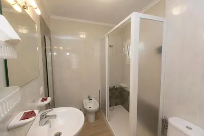 a white bathroom with a sink and a toilet at Casa Melva in Barreiros