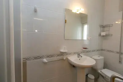 a white bathroom with a sink and a mirror at Casa Melva in Barreiros