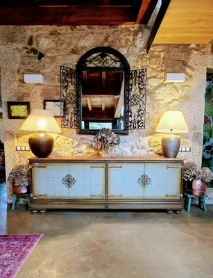 a stone wall with two lamps and a mirror at Galician Stone House Santiago in Ramallosa