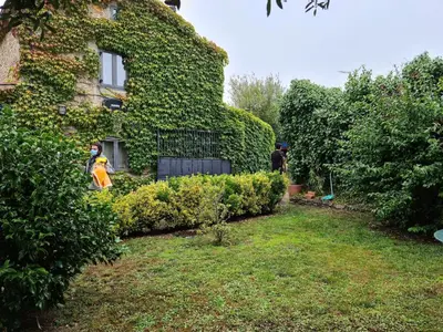 a person standing in front of a house covered in ivy at Galician Stone House Santiago in Ramallosa