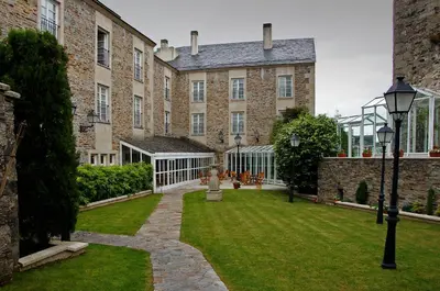 a large brick building with a lawn in front of it at Parador de Vilalba in Villalba