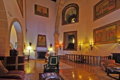 a large room with chairs and paintings on the walls at Parador de Vilalba in Villalba