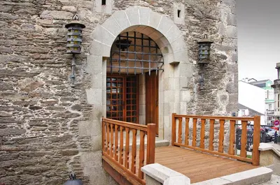 a building with a wooden porch and a door at Parador de Vilalba in Villalba
