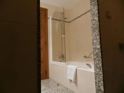 a bathroom with a tub and a sink and a mirror at Parador de Vilalba in Villalba