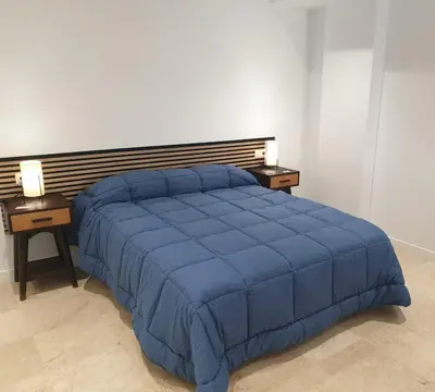 a blue bed in a bedroom with two night stands at XELIÑA e in A Estrada