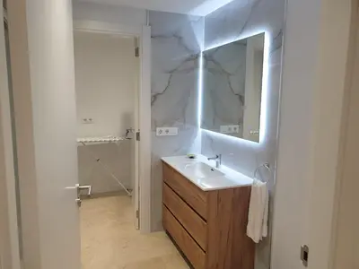 a white bathroom with a sink and a mirror at XELIÑA e in A Estrada