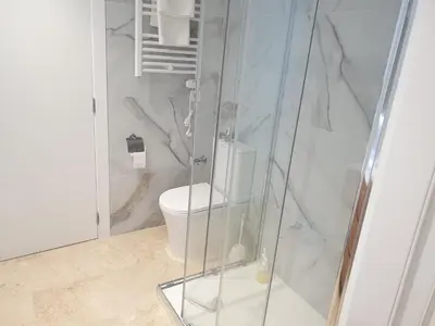 a bathroom with a toilet and a glass shower at XELIÑA e in A Estrada