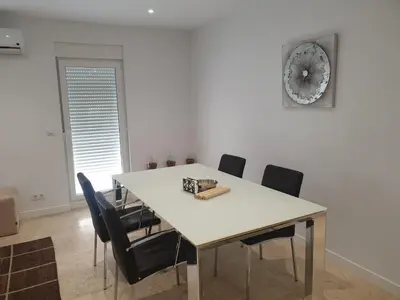 a dining room table with chairs and a clock on the wall at XELIÑA e in A Estrada