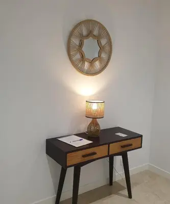 a table with a lamp and a mirror on a wall at XELIÑA e in A Estrada