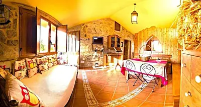 a living room with a table and a stone wall at A Casa do Aloumiño da Auga Mondariz VT-PO-00148 y SPA Prexigueiro Obsequio entrada por persona a circuito termal in San Félix