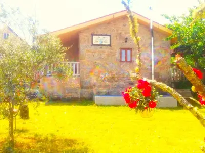 a house with a bunch of flowers in front of it at A Casa do Aloumiño da Auga Mondariz VT-PO-00148 y SPA Prexigueiro Obsequio entrada por persona a circuito termal in San Félix