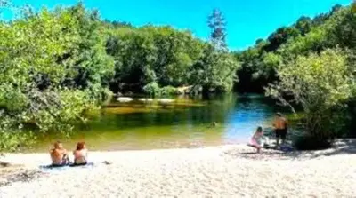 a group of people sitting on a beach near a river at A Casa do Aloumiño da Auga Mondariz VT-PO-00148 y SPA Prexigueiro Obsequio entrada por persona a circuito termal in San Félix