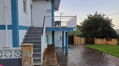 a dog sitting on the stairs of a house at Vivienda vacacional Casa Rubieiro