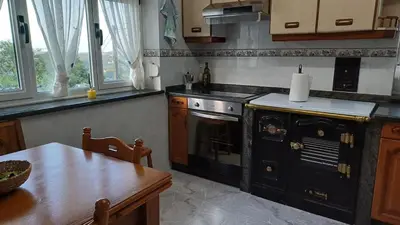 a kitchen with an old stove and a table at Vivienda vacacional Casa Rubieiro