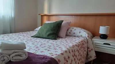 a bedroom with a bed with green and pink pillows at Vivienda vacacional Casa Rubieiro