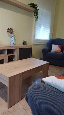 a living room with a wooden table and a couch at Vivienda vacacional Casa Rubieiro