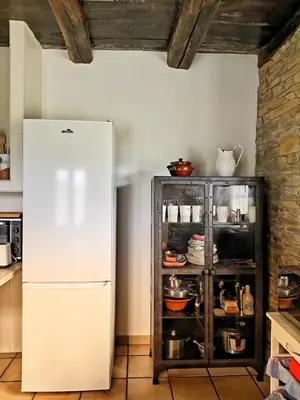 a white refrigerator in a kitchen next to a brick wall at 39A01 La Casita Olga Casa en plena naturaleza by R2R Consulting in Arrojo