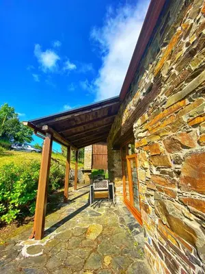 a stone house with a bench on a patio at 39A01 La Casita Olga Casa en plena naturaleza by R2R Consulting in Arrojo