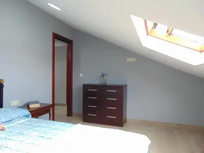 an attic bedroom with a bed and a skylight at Casa Esperanza 8 huéspedes