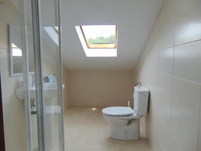 a bathroom with a toilet and a skylight at Casa Esperanza 8 huéspedes