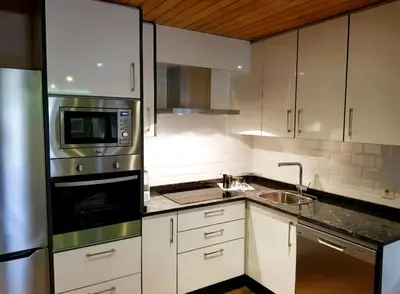 a kitchen with white cabinets and a stainless steel appliance at Buleiro in Ourense