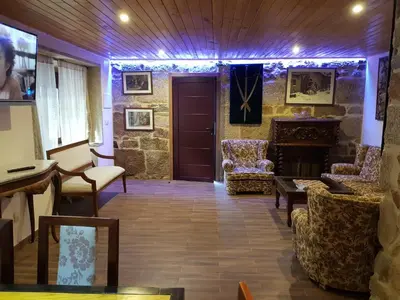 a living room with a door and chairs and a fireplace at Buleiro in Ourense