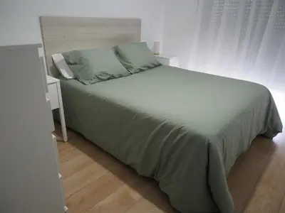 a bedroom with a large bed and a night stand at Rúa Mariñeiro in Burela de Cabo